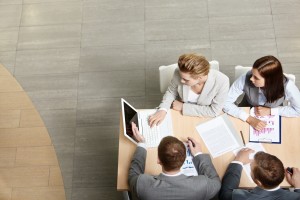 Image of business partners sitting at table and planning work